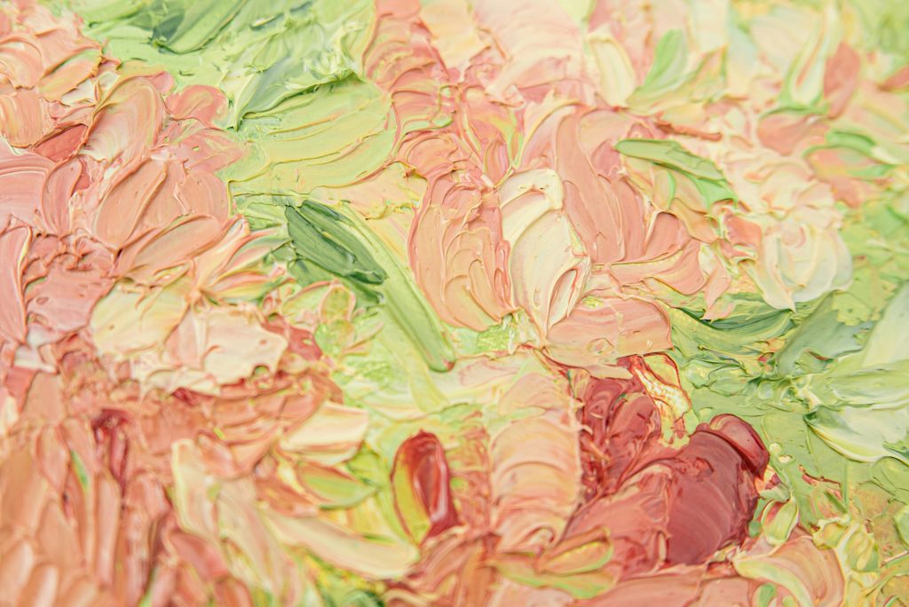Peinture abstraite en épaisseur avec des touches de vert, rose, jaune et rouge, créant une texture riche et dynamique.